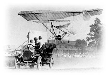 William H. Martin in his monoplane, with Almina P. Martin in the car