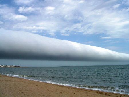A Roll Cloud Over Uruguay  Credit & Copyright: Daniela Mirner Eberl  Explanation: What kind of cloud is this? A roll cloud. These rare long clouds may form near advancing cold fronts. In particular, a downdraft from an advancing storm front can cause moist warm air to rise, cool below its dew point, and so form a cloud. When this happens uniformly along an extended front, a roll cloud may form. Roll clouds may actually have air circulating along the long horizontal axis of the cloud. A roll cloud is not thought to be able to morph into a tornado. Unlike a similar shelf cloud, a roll cloud, a type of Arcus cloud, is completely detached from their parent cumulonimbus cloud. Pictured above, a roll cloud extends far into the distance in 2009 January above Las Olas Beach in Maldonado, Uruguay.