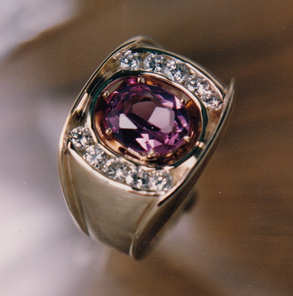 Hand carved gold ring with large cushion shaped amethyst surrounded by channel set diamonds.