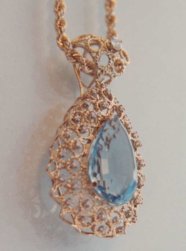 Hand wrought twisted gold wire blue topaz pendant.