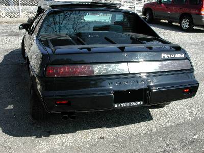 2M4 Fiero by Pontiac from the rear with a Pontiac Fiero kid