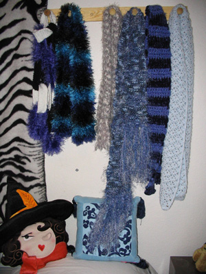 L to R: Knitted Chain Link Scarf, Knitted Stripe Fun Fur Scarf, Knitted Silver Scarf, Knitted Denim Blue Scarf, Crocheted Purple Stripe Witchy Scarf, Crocheted Beaded Baby Blue Scarf.