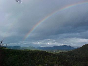 A rainbow on a cloudy day with the Smoky Mts. in the background