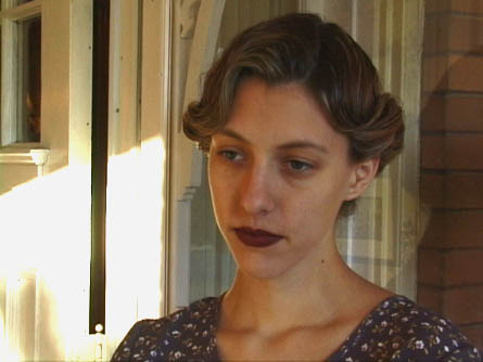 [Ann (Alicia Stanton) watches her husband leave.]