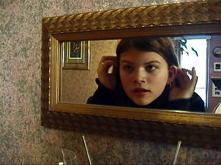 [Michelle (Janet Baldwin) does a quick 2 second makeover just before her boyfriend Paul (Erik Woods) enters the house.]