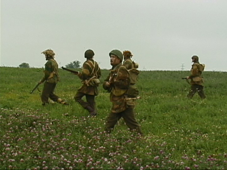 [The Canadian soldiers walk in the farmers field.]