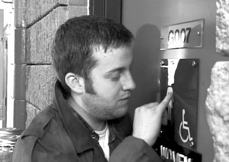 [THE STRANGER (Scott Harris) snoops around the trainstation.]