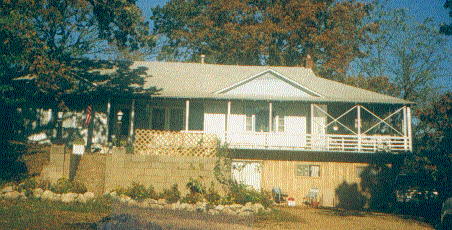 The open porch is on the upper right corner of the house, to the right of the window in the center.