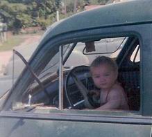 Joanne in the car in 1961 just 8 months old. Quite the driver eh?