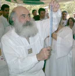 Guru Carlos Moises Michan Amiga sosteniendo una cruz para las honorificaciones entregadas en Enero 18, 2000