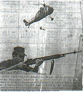 L/Cpl Marty Winkel with his M-14 rifle covers while L/Cpl Enrique del Rosario rappels from an HMM-365 UH-34D