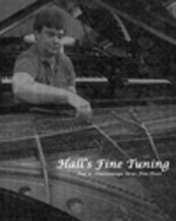 Photo of piano Technician Chris Hall tuning a grand piano.