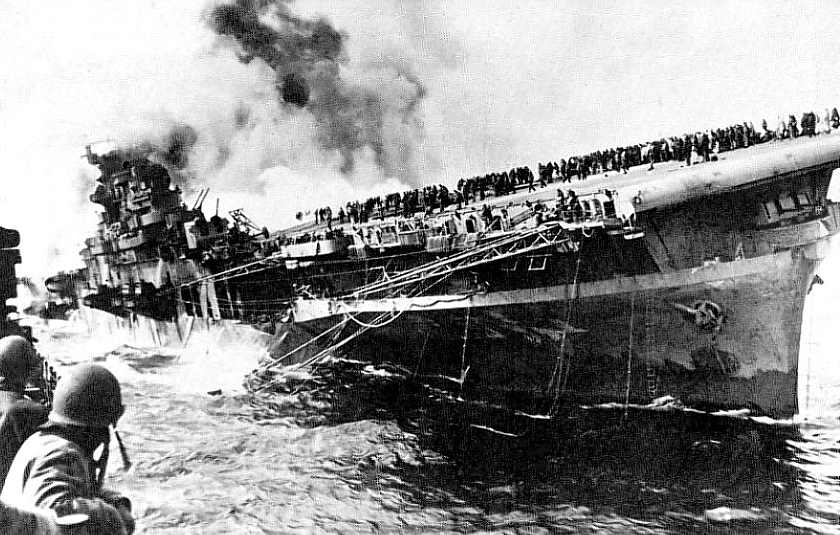USS 'Franklin'  -  photograph showing the carrier listing and ablaze on 19 March 1945,  after being bombed by Japanese aircraft off Kyushu