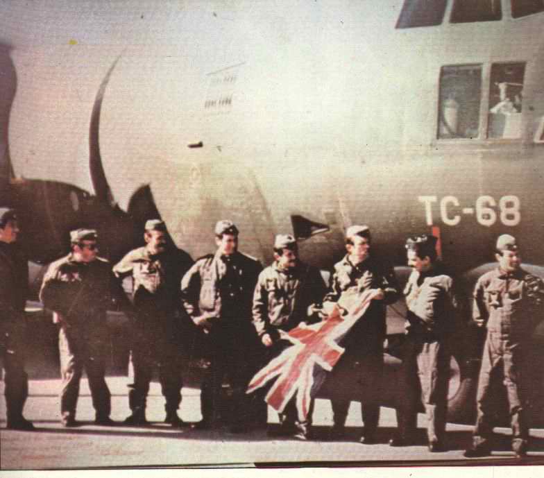La tripulación que concretó el primer aterrizaje de un Hércules en el recién tomado aeropuerto de Malvinas, posa frente al aparato -TC-68-con una bandera inglesa que capturaron. El C-130 que haría el último vuelo a las islas sería el TC-65.