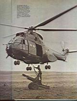 Un helicóptero Puma del Batallón 601 de Aviación del Ejército se apresta a cargar un oto Melara de 105 mm. Para trasladarlo en vuelo. Un asistente se presta a engancharlo a la eslinga de carga.