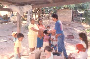 Claudio Acevedo haciendo entrega de calzados a Pastora e hija