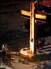 Workers at the World Trade Center disaster site look at a large illuminated cross near the rubble of the collapsed buildings on Wednesday.