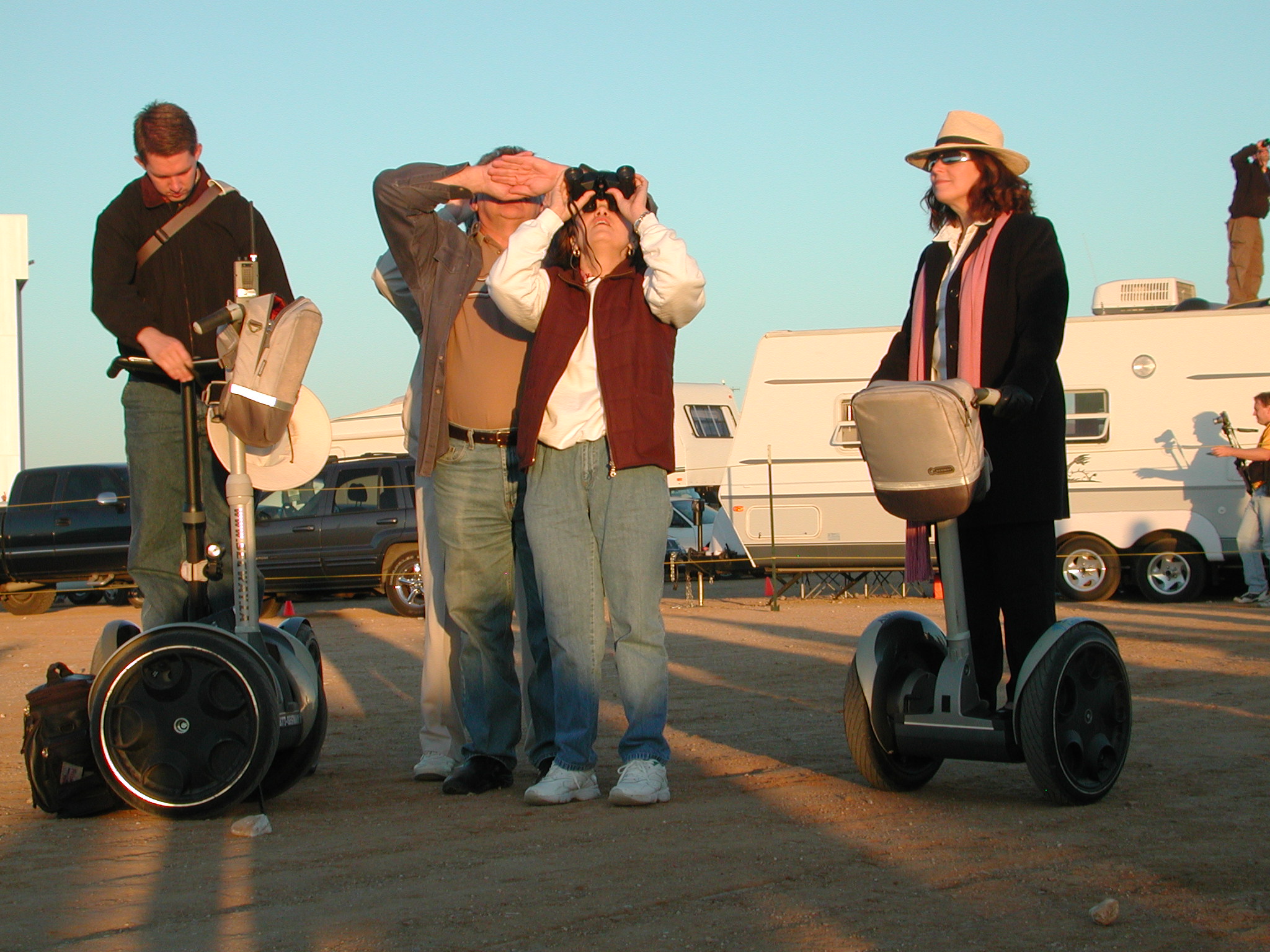 image: two people watching flight, two on segways seemingly oblivious