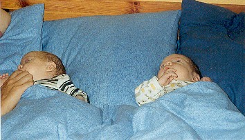 I sängen hemma. Obs! Mammas pekfinger!