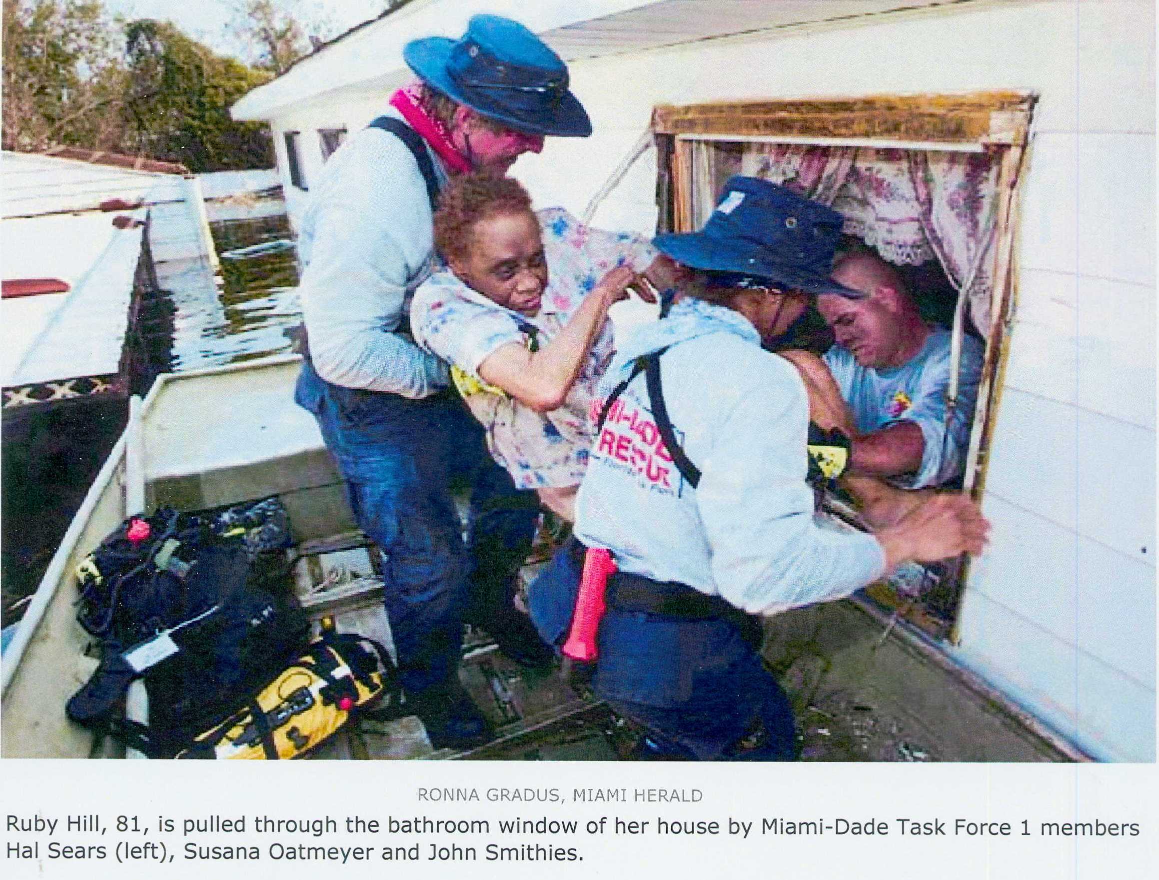 Three Miami-Dade Task Force members help elderly woman out of window