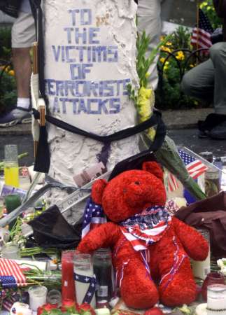 A teddy bear sits at a memorial to victims of the World Trade Center disaster in Union Square Park in New York September 14, 2001. The World Trade Center towers collapsed September 11 after being attacked by hijacked commercial airliners. REUTERS/Jeff Christensen