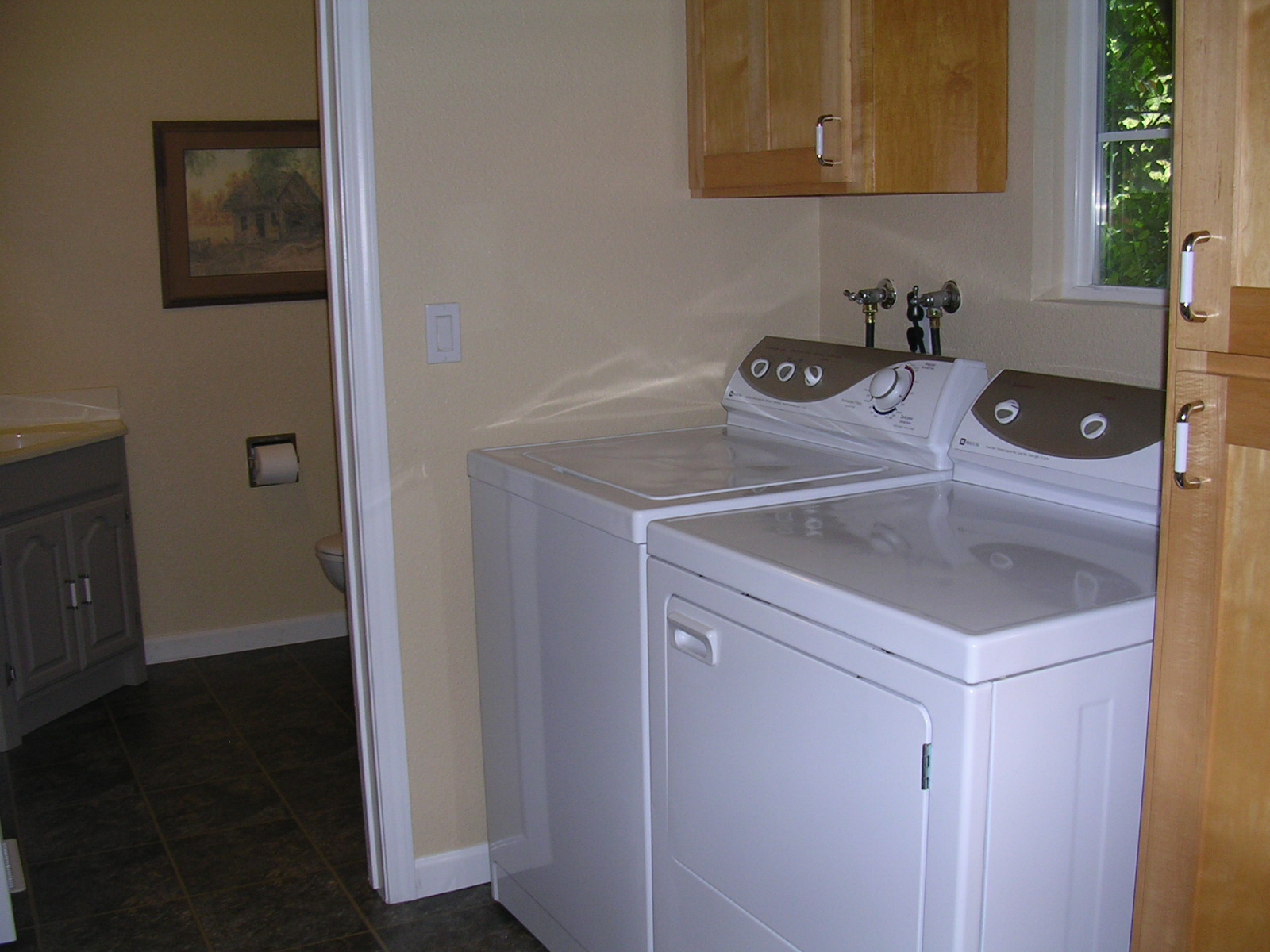 Upstairs laundry room with half bath located off kitchen.