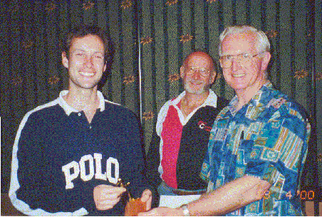 Owen Heness presents Dave Osmond with the mountain running trophy as Dudley Scoullar looks on