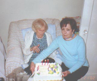 Brigid views cake held by dau Mona