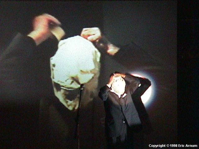 Channing Hansen (Beck's brother) and his grandfather (on screen) wrapping their heads with masking tape at a 'Happening', at the Roxy, NYC, Sept 17 1998