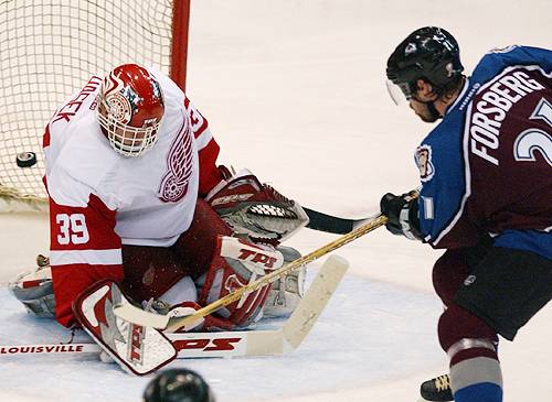 This one's going by.
Peter Forsberg scores the winning goal against goaltender Dominik Hasek. The 2-1 victory for the Avs gave them a 3-2 series lead. (REUTERS/Rebecca Cook) May 27, 2002