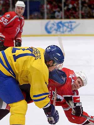 Sweden Olympic hockey team player Peter Forsberg (11) falls to the ice with Canadian player Chris Pronger(24), in first period action, Saturday, Feb. 14, 1998, at the Big Hat arena in Nagano. ( Photo/Hans Deryk) 