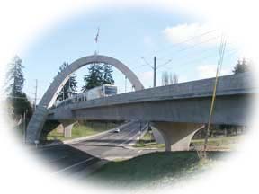 El puente del arco lleva el tren del MAX sobre E. Main Street