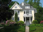 Picture of 65 Kenyon:  Pale yellow shingle Victorian with ornate white trim and round front porch