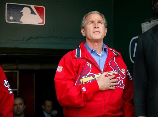 President George W. Bush stands for the playing of the national anthem in the St. Louis Cardinals dugout during their season opener against the Milwaukee Brewers Monday, April 5, 2004. As part of the opening ceremonies for the 2004 baseball season, President Bush threw out the first pitch. White House photo by Eric Draper