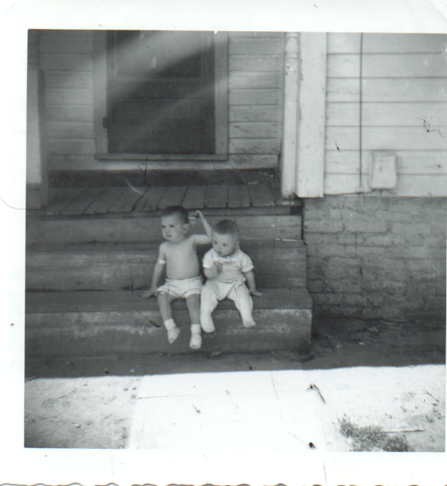 my uncle and my second cousin sitting on what I beleive is the frount steps