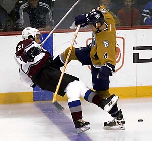 Nashville Predators defenseman Mark Eaton (4) checks Colorado Avalanche center Peter Forsberg (21) to the ice.. Avs 3, Nash 1. 2002-11-14. Credit: AP, www.dailycamera.com
