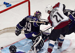 Peter Forsberg slides the puck past Kings goalkeeper Felix Potvin for his second goal of the game in the third period. LA Kings 1, Avs 6. 2002-12-29. Credit: AP, www.dailycamera.com
