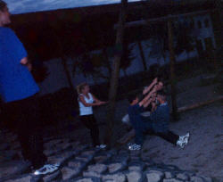 Markus U. and Lori laugh at Thomas, Nico, and Dustin as they try to ride the swing together.