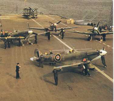 Ca�a Seafire IIC no conv�s de um porta-avi�es, ao fundo um Fairey Albacore.