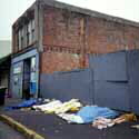 row of sleepers on the sidewalk in the morning, covered with tarps