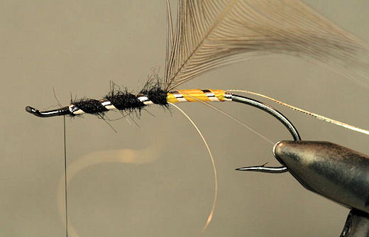 Next wrap the flat silver tinsel foreword followed by the oval silver tinsel, tie them off and trim the excess.