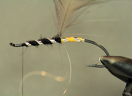 Next wrap the flat silver tinsel forward followed by the oval silver tinsel, tie them off and trim the excess.