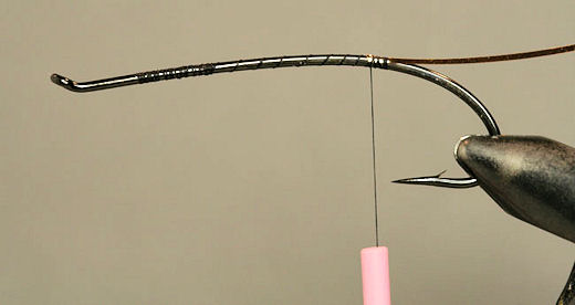 Run the thread back and stop just before the hook point and tie in some flat silver tinsel