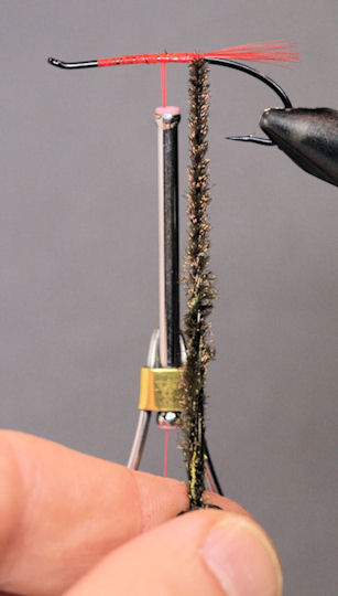 Once the materials are securely griped by the hackle pliers twist them into a rope.