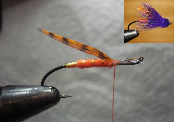 Wrap 4 strands of Krystal Flash forward four turns through body. Tie in 2 matched grizzly hackle tips, not to extend beyond hook shank.