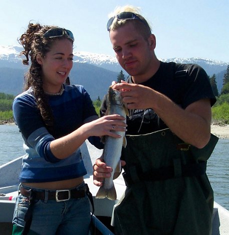 Kylah Dryvynsyde is being assisted by Eric Chisholm with her first Dolly Varden, May 2004 on the Kitimat River in British Columbia.