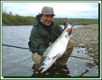Yuri Shumakov holds up a feshly caught Atlantic Salmon from Kola river, June 2003