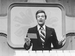 Wink behind the podium from the pilot episode