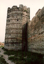 A polygonal wall tower with a postern next to the flanking wall